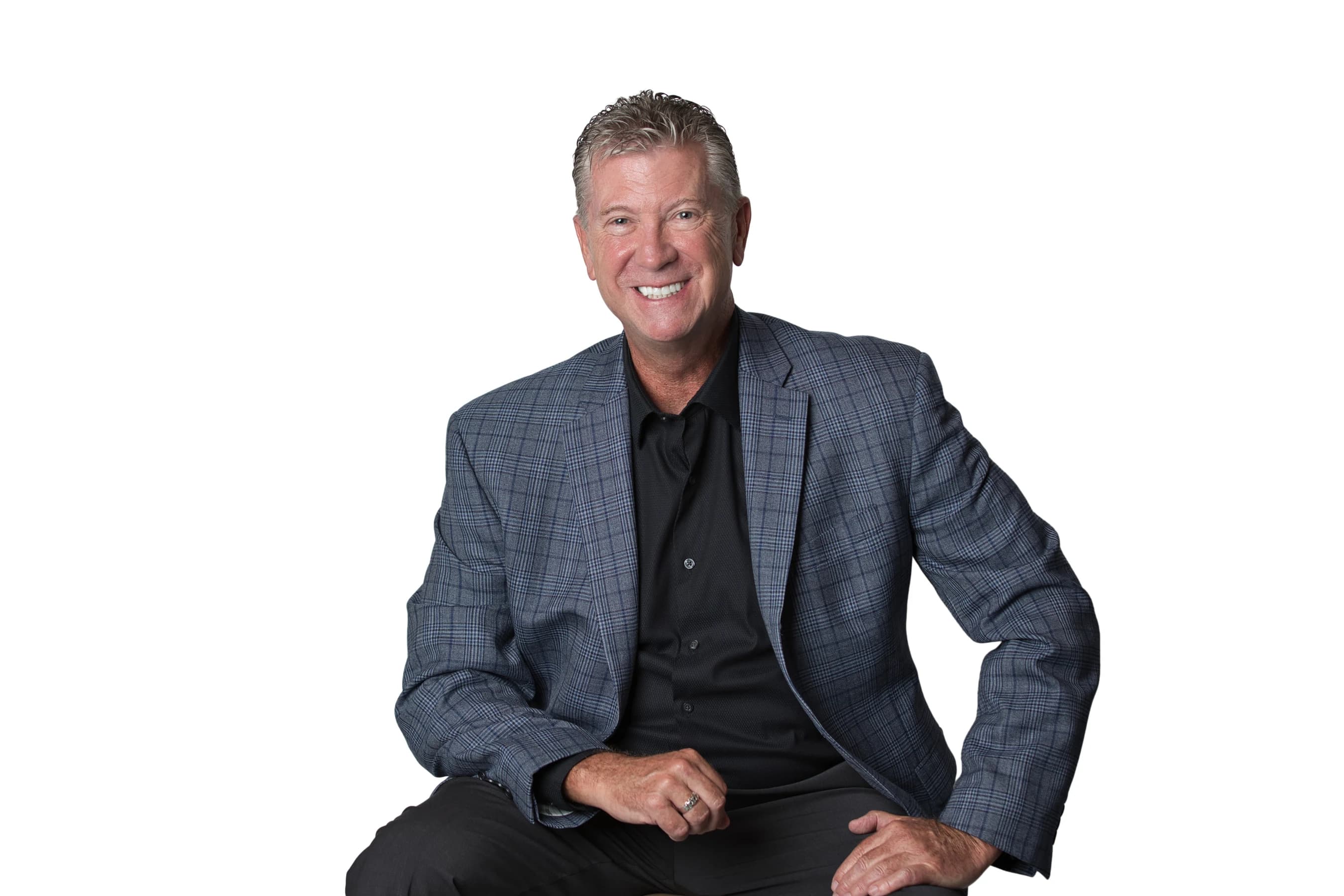 Bob Crews seated in a blue checked jacket and black shirt