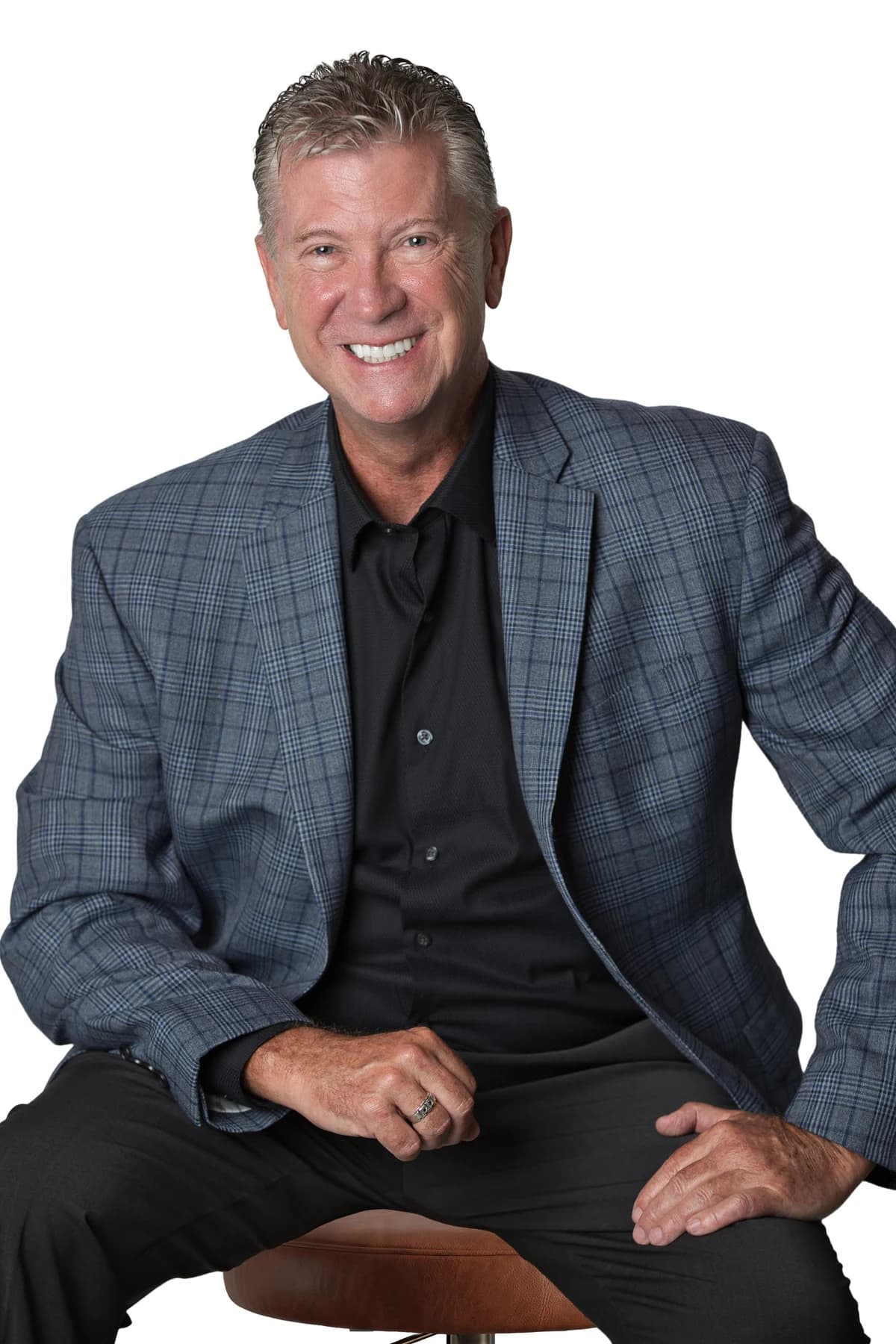 Bob Crews seated in a blue checked jacket and black shirt