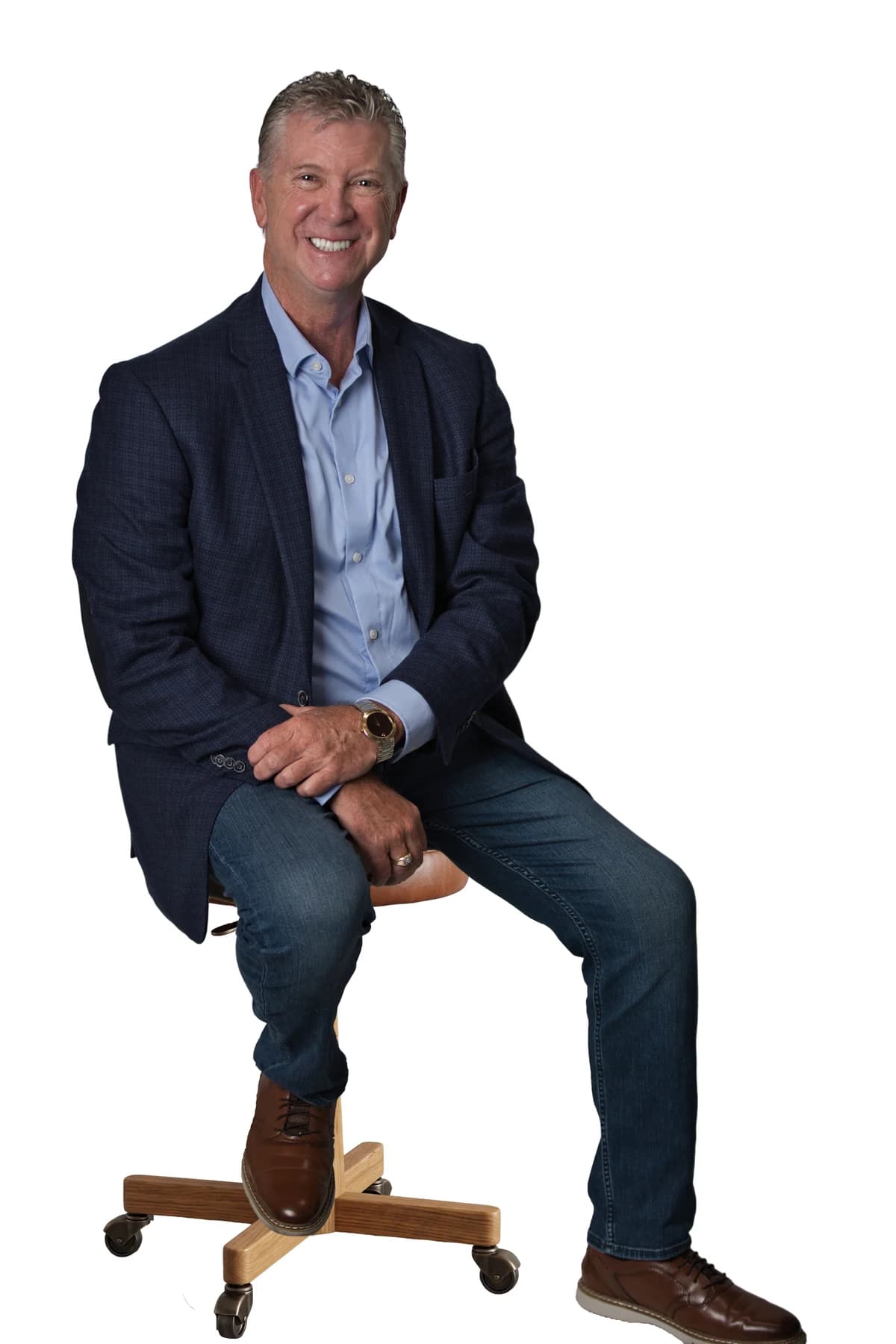 Bob Crews seated on a stool in a blue jacket, blue shirt and jeans